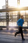 Mann joggt auf Brücke, München, Bayern, Deutschland — Stockfoto