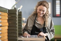 Woman with letterpress tray in printing workshop — Stock Photo
