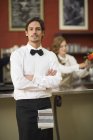 Ritratto di cameriere con le braccia incrociate nel ristorante — Foto stock