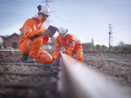 Працівники залізничного технічного обслуговування з використанням цифрової планшета для перевірки треку в Llogборо, Англія, Великобританія — стокове фото