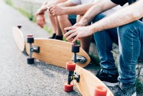 Young men sitting with skateboards — Stock Photo