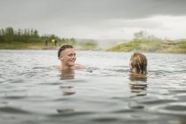 Casal jovem relaxante na fonte termal Secret Lagoon (Gamla Laugin), Fludir, Islândia — Fotografia de Stock