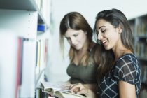 Young pretty women studying in library — Stock Photo