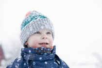 Toddler boy standing in snowy countryside field — Stock Photo
