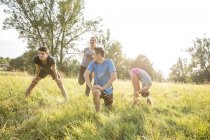 Grupo de amigos se exercitando em campo — Fotografia de Stock