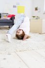Girl trying to do headstand at home — Stock Photo