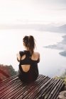 Rear view of young woman on balcony looking out over Lake Atitlan — Stock Photo