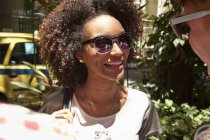 Молода жінка в сонцезахисних окулярах, посміхаючись — стокове фото