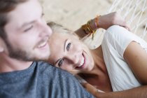 Gros plan du jeune couple souriant sur l'hamac de plage — Photo de stock