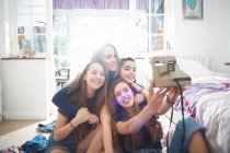 Quattro ragazze adolescenti che scattano selfie fotocamera istantanea in camera da letto — Foto stock