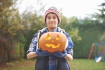 Boy with pumpkin posing in garden — Stock Photo