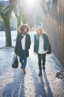 Two young female friends strolling along street, Como, Italy — Stock Photo