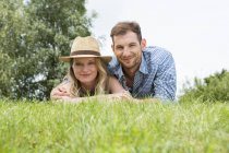 Mitte erwachsenes Paar im Gras liegend, Portrait — Stockfoto