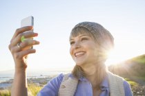 Jeune femme prenant selfie avec smartphone — Photo de stock
