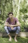 Young man sitting in garden — Stock Photo