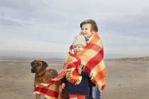 Portrait of three year old girl and brother wrapped in blanket on beach, Bloemendaal aan Zee, Netherlands — Stock Photo