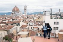Visão traseira do casal lésbico em pé do terraço do telhado olhando para a vista — Fotografia de Stock