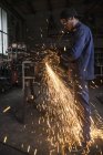 Welder cutting iron in workshop interior — Stock Photo