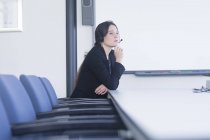 Telefonista contemplando na sala de reuniões — Fotografia de Stock