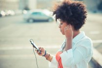 Молодая женщина слушает музыку для смартфонов — стоковое фото