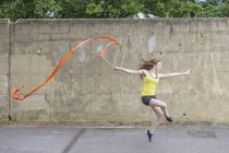 Молода жінка практикує стрічковий танець на дворі — стокове фото