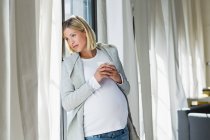 Full term pregnancy young woman daydreaming whilst drinking coffee — Stock Photo