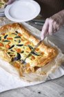 Cropped shot of person cutting butternut squash filo pastry tart — Stock Photo