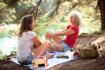 Mother and daughter on picnic blanket by Blue Pool, Wareham, Dorset, United Kingdom — Stock Photo
