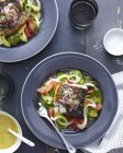 Plate of barramundi fish with vegetables and a herb garnish — Stock Photo