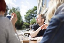 Friends having lunch in cafe by canal — Stock Photo