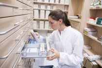 Pharmacist opening medicine file drawer — Stock Photo
