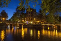 Canal waterfront and bridge at night, Amsterdam, Netherlands — Stock Photo