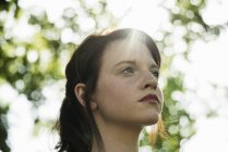 Close up portrait of serene young woman in park — Stock Photo