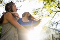 Duas meninas adolescentes dançando no parque iluminado pelo sol — Fotografia de Stock