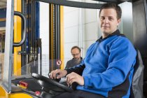 Factory worker operating forklift — Stock Photo