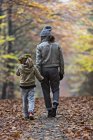 Mother and daughter walking in autumn forest — Stock Photo
