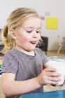 Portrait of girl holding glass of milk — Stock Photo