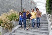 Группа друзей спускается по ступенькам вместе — стоковое фото