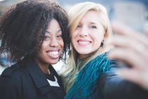 Dos mujeres jóvenes posando para selfie Smartphone - foto de stock