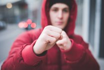 Close up of young mans posing with clenched fists on city street — Stock Photo