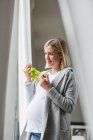 Full term pregnancy young woman eating grapes — Stock Photo