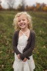 Портрет дівчини-дошкільника, яка посміхається на відкритому повітрі восени — стокове фото