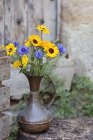 Flores frescas en jarra de metal, al aire libre - foto de stock