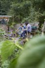 Two men and boy sitting on allotment bench — Stock Photo