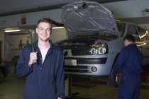 Portrait of male student mechanic in college garage — Stock Photo