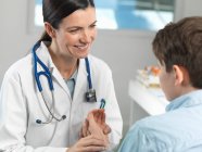 Medico controllando il polso del ragazzo in clinica — Foto stock