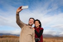 Pareja tomando selfie en el campo, Connemara, Irlanda - foto de stock