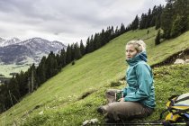 Female hiker stopping for a beer on the way down from Zinken mountain, Oberjoch, Bavaria, Germany — Stock Photo