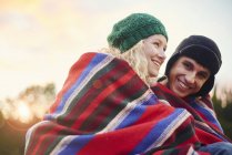 Portrait of romantic young camping couple wrapped in blanket — Stock Photo