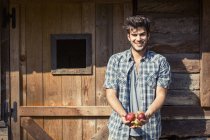 Retrato de jovem agricultor do sexo masculino segurando maçãs, Premosello, Verbania, Piemonte, Itália — Fotografia de Stock